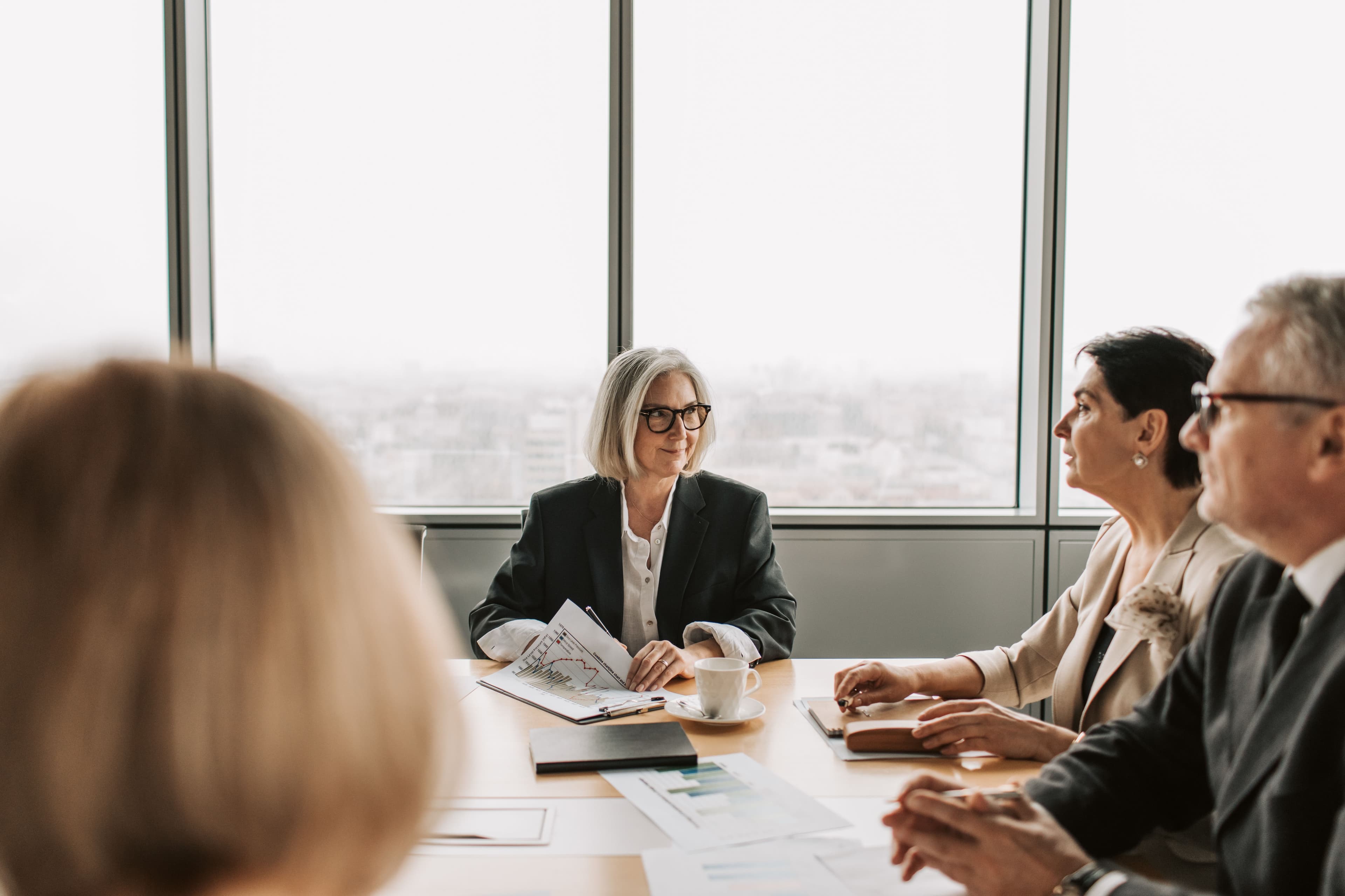 Leadership team in a meeting with printed charts on the table